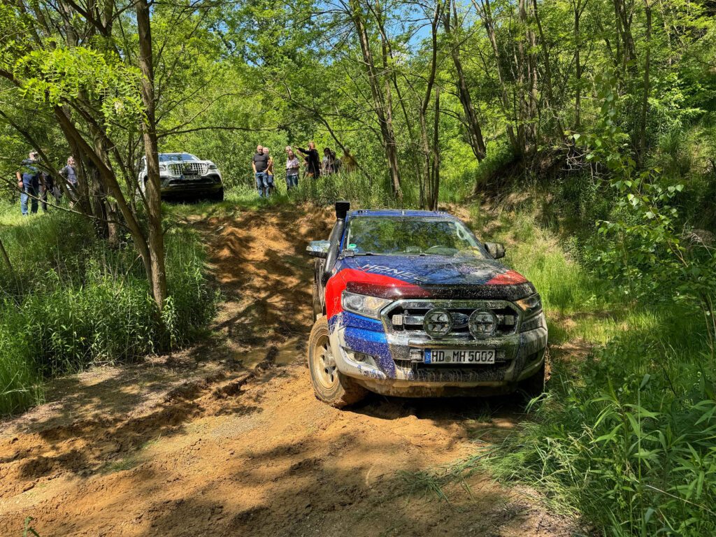 Tischer_Treffen_25_Ford Ranger mit Tischer Kabine bei einer Offroad-Testfahrt im Wald – Zuschauer im Hintergrund.