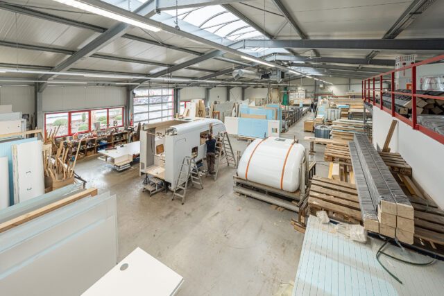 Blick in die Fertigungshalle – mehrere Tischer Wohnkabinen aufgeständert zur Montage.