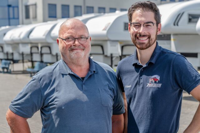 P. Sauer und Herr Tischer auf dem Firmengelände vor mehreren Absetzkabinen
