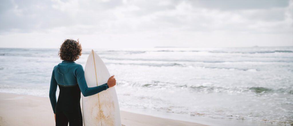 Portrait of a young surfer boy looking at the sea