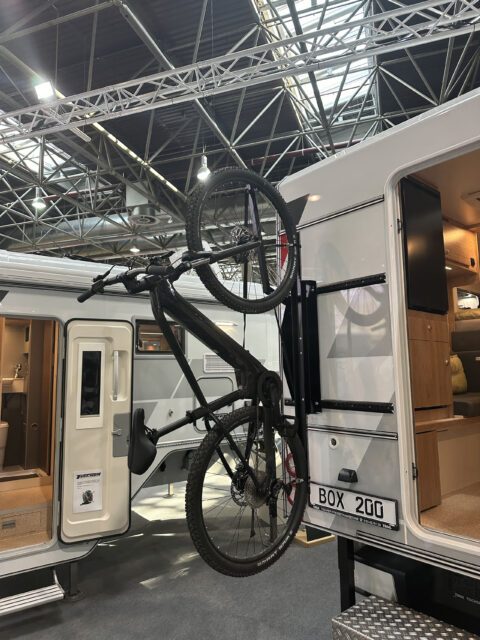 Fahrrad montiert am Heckträger einer Tischer BOX 200 Wohnkabine auf der Messe.